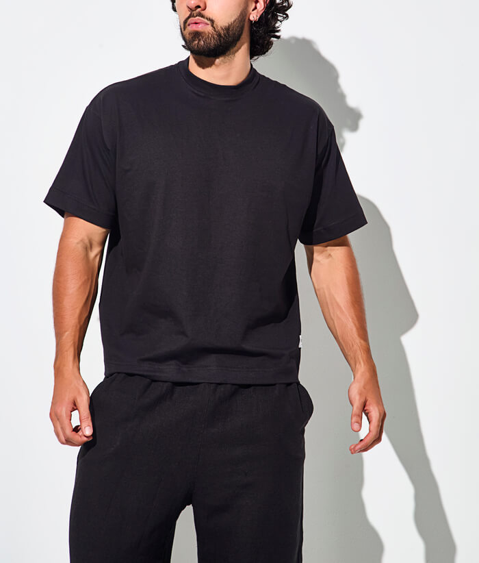 Camiseta t shirts hombre uno frente - Hombre vistiendo camiseta negra oversize de estilo casual.