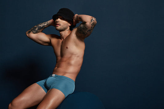 Bañadores - Hombre en bóxer azul y sombrero oscuro posando sobre fondo azul