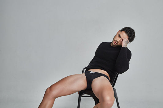 Como bañarse bien guía - Hombre en suéter negro y ropa interior oscura recostado en silla