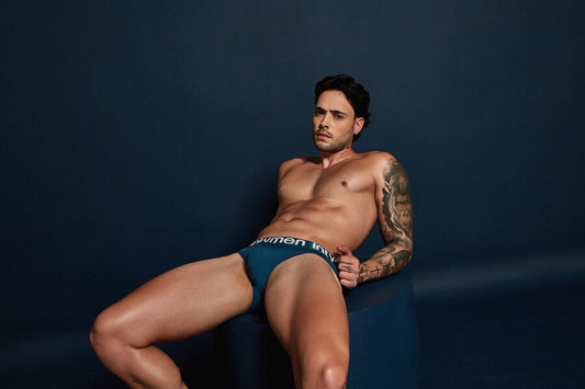 Partes intimas masculinas curiosidades - Hombre en ropa interior azul recostado sobre fondo azul oscuro