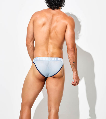 Hombre de espaldas modelando brief azul claro Intymen de malla con pretina blanca