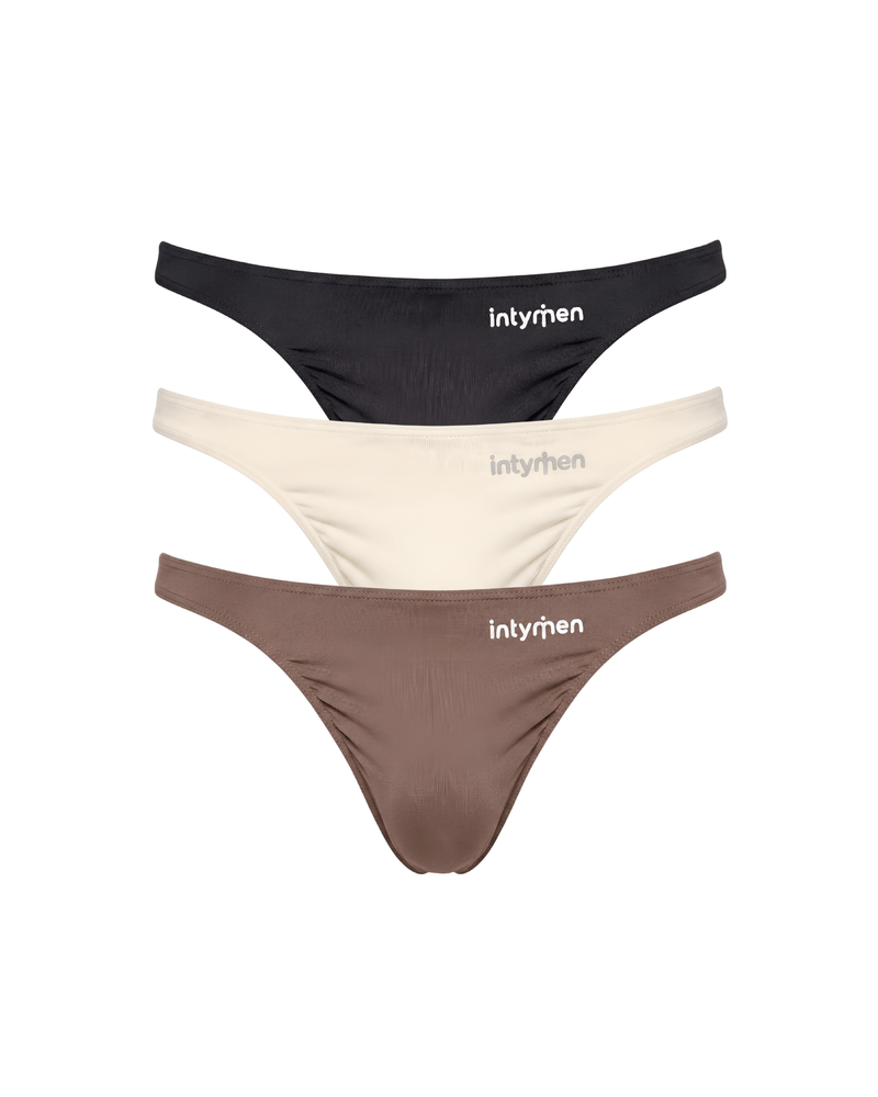 Tres tangas masculinas Intymen en colores negro, beige y marrón sobre fondo blanco.